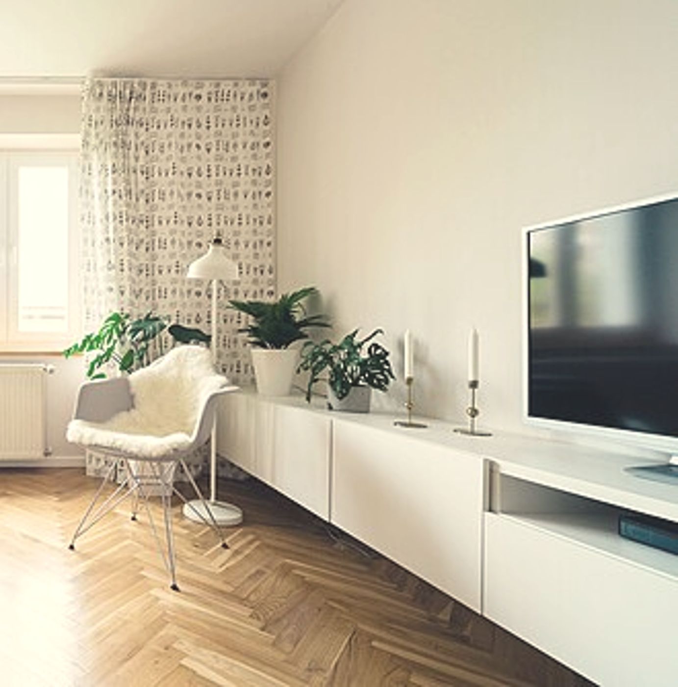 Een lichte woonkamer met visgraatvloer en planten